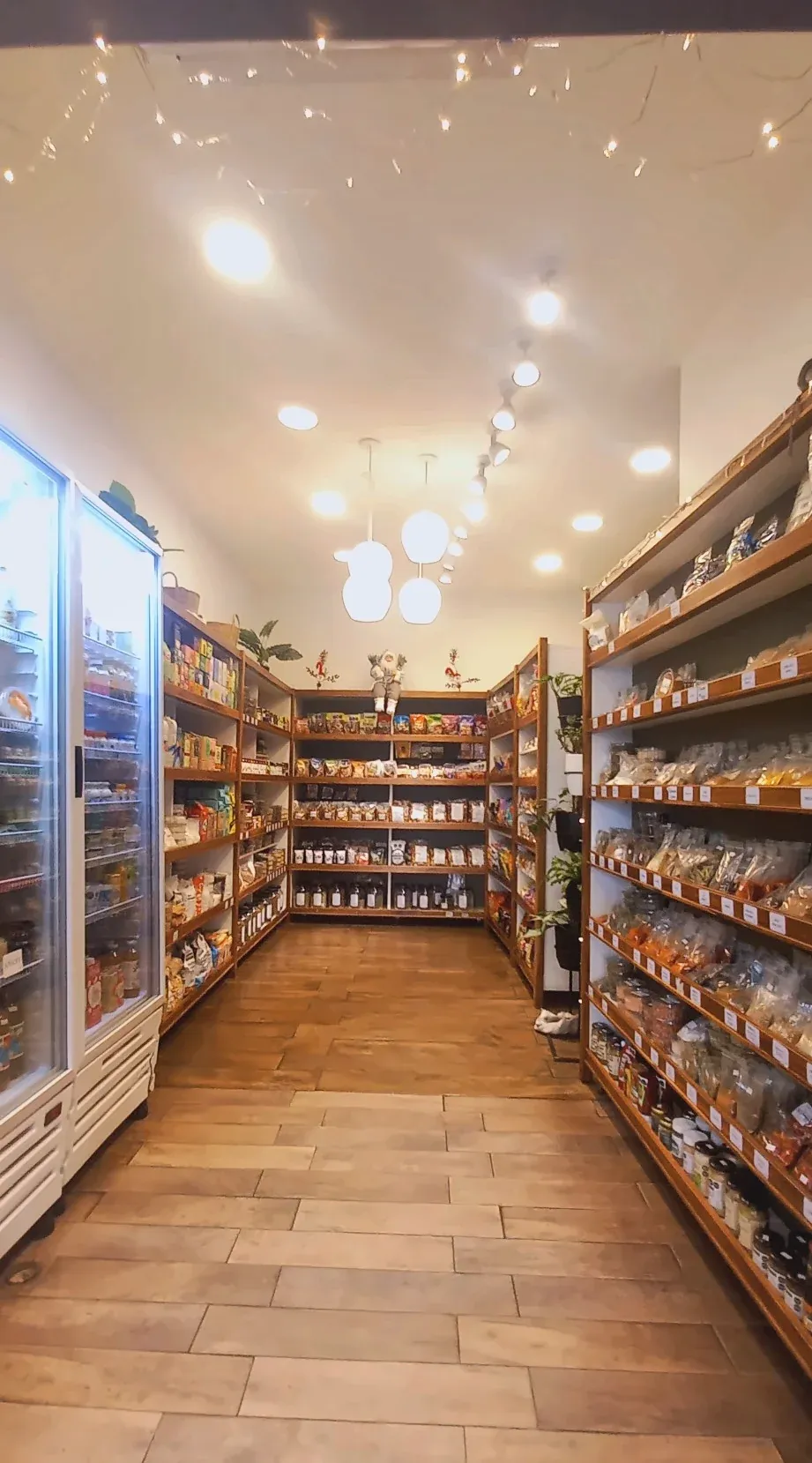 Pasillo de la almacén con góndolas de madera a ambos lados y heladeras