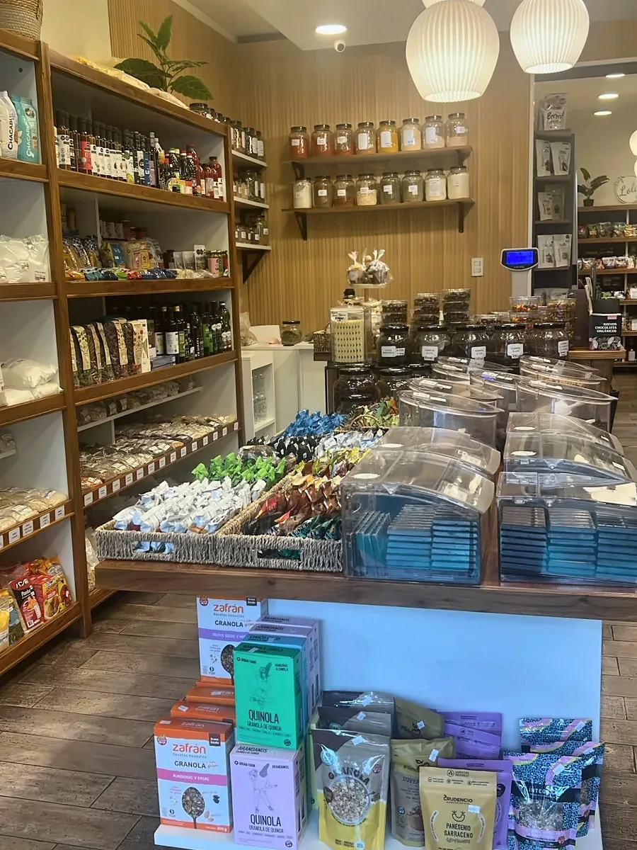 Interior con estanterías de madera, granel y golosinas a la vista