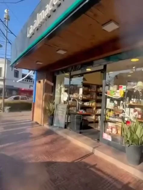 Vista desde la vereda hacia la entrada vidriada de la almacén
