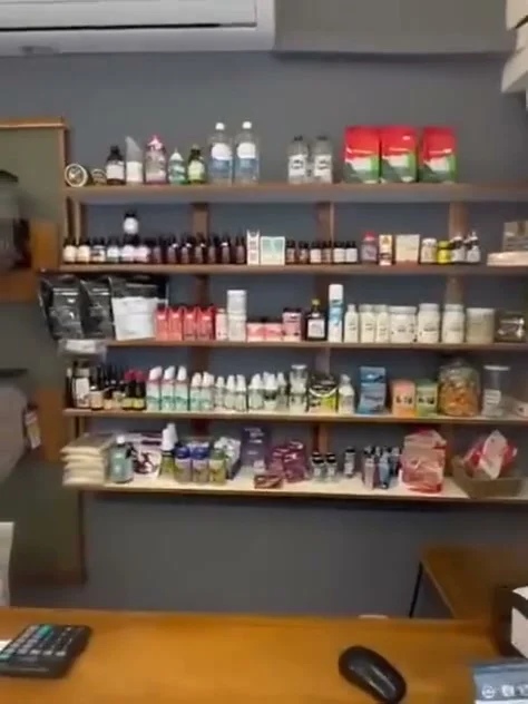 Mostrador de madera con estantes de frascos y productos detrás