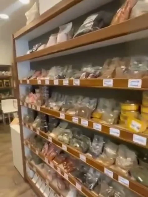 Estantes de madera con bolsas de frutos secos y legumbres a granel